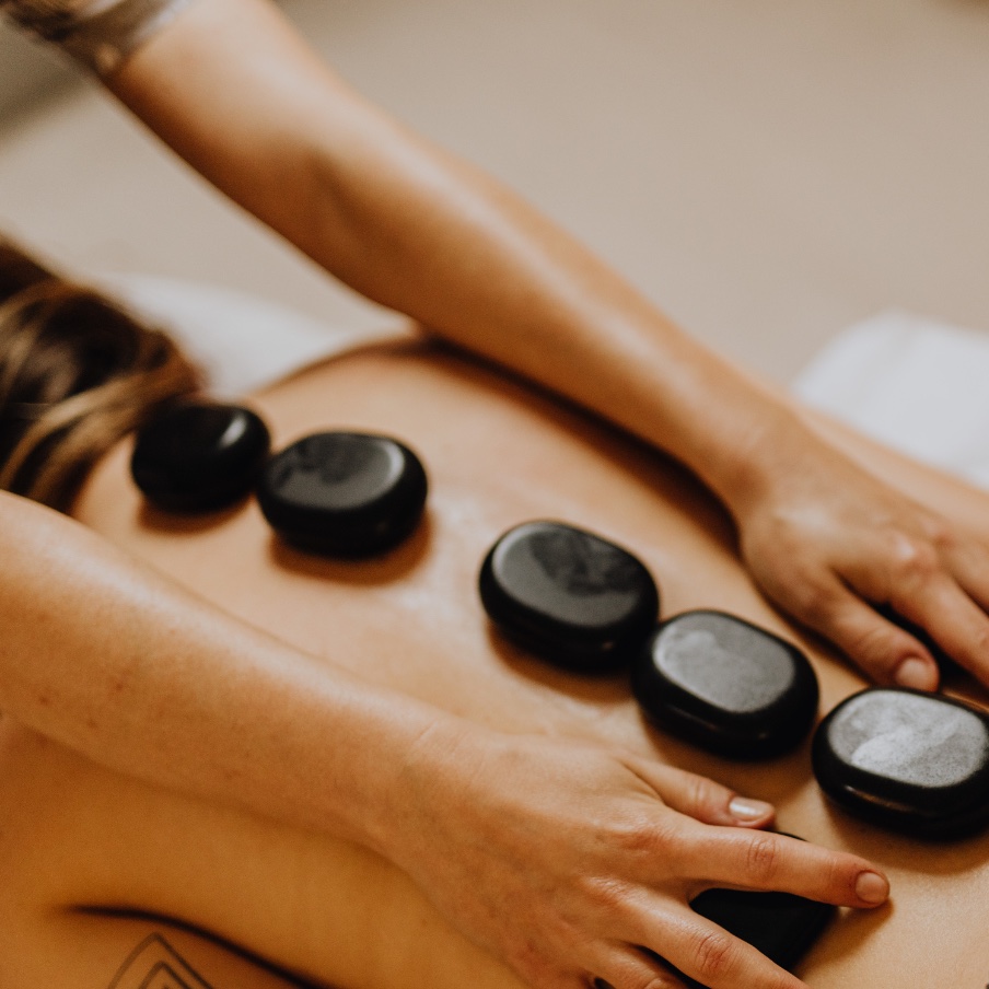 Hot-Stone-Massage — warme Basaltsteine entlang der Wirbelsäule